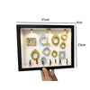 Schwarze Präsentationsbox mit verschiedenen Gold- und Silberresin-Silhouettenrahmen und einem hängenden Goldstück.