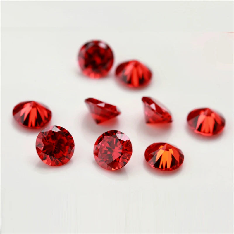 A collection of various round and triangular red and orange cubic zirconia loose stones for jewelry making.