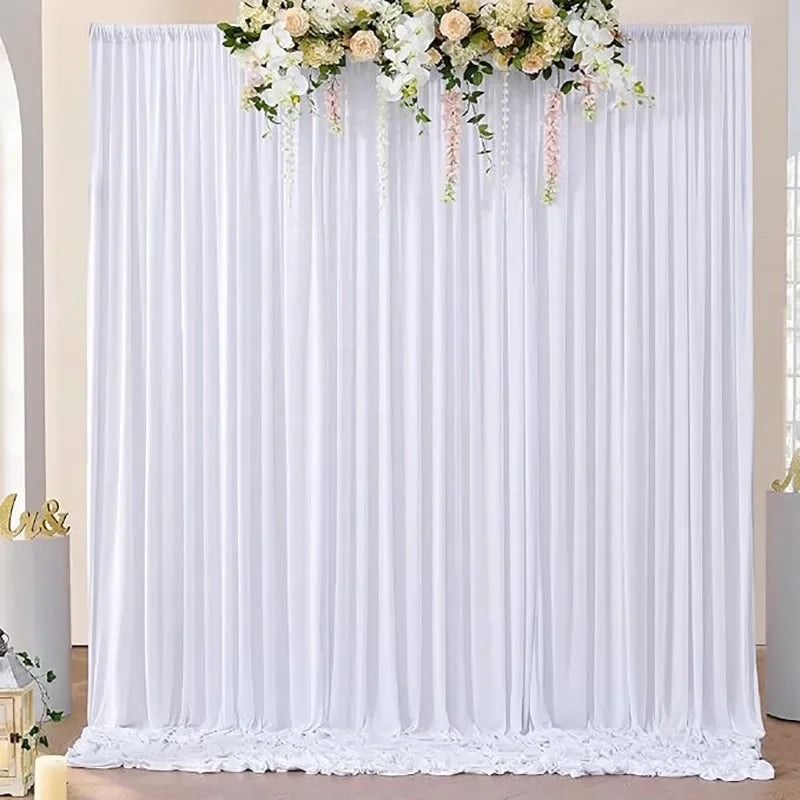Wrinkle-free white backdrop curtain with floral greenery and pink accents for weddings and events