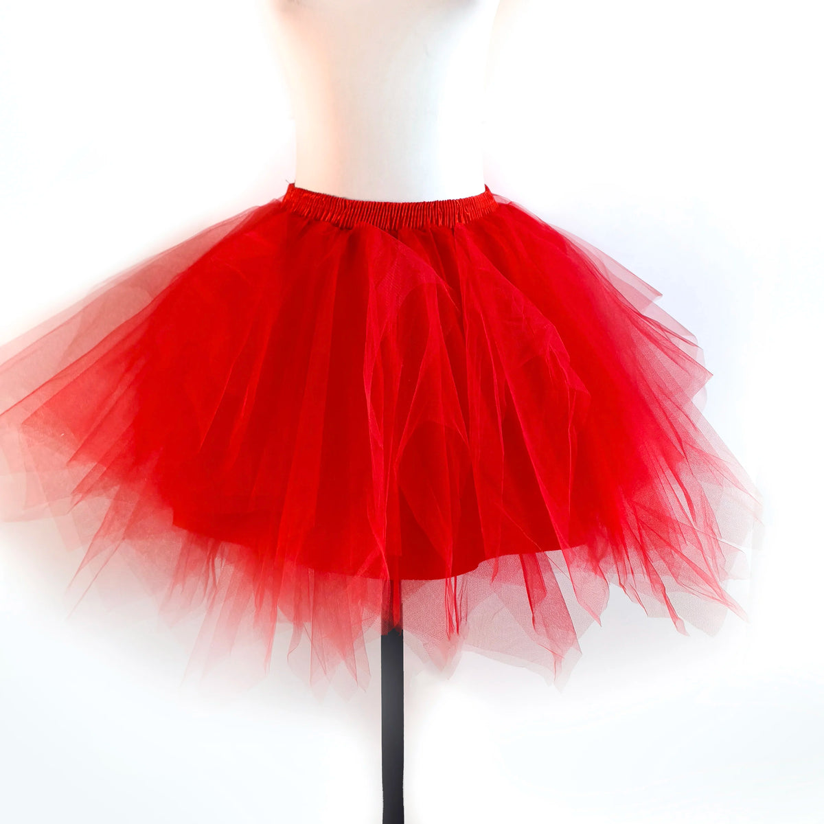 A bright red tulle tutu skirt displayed on a mannequin.