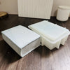 A white openable book-shaped silicone mold for resin and concrete DIY sits on a dark wooden surface.