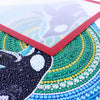 Close-up of a magnetic poster display frame featuring intricate green and blue beadwork designs.