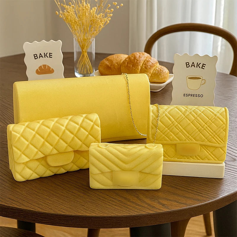 Yellow silicone handbag candle mold for DIY aromatherapy and chocolate crafts displayed on a wooden table.