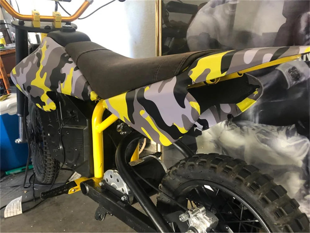 A yellow bicycle is shown with a black seat and digital camouflage vinyl wrap film applied to the frame.