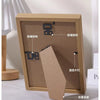 A wooden photo frame displaying various results, including a fixed print and a removable cover.