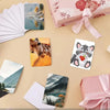 A collection of photo cards and a pink gift box with a ribbon on a beige background.