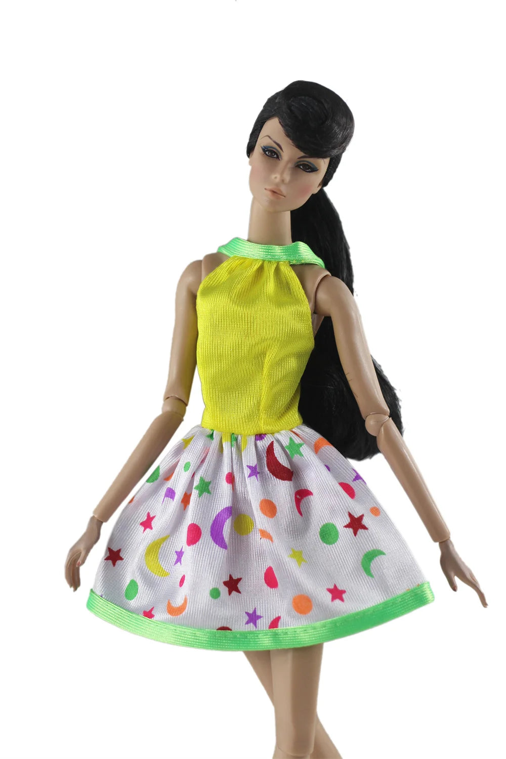 A handmade doll dress gown featuring a yellow bodice and a white skirt with colorful stars and moons.