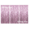 Three vertical panels of metallic pink foil fringe curtains used for party backdrop decor.
