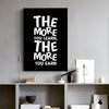 Black canvas art poster with white text that reads The more you learn the more you earn