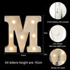 A large, three-dimensional letter M made of light-emitting diodes with warm white illumination.