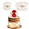 Clear acrylic cake stand display box with LED lights featuring a tiered cake decorated with red roses and white flowers.