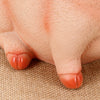 A close-up of a hand holding an adorable pink piggy bank made of durable resin.