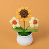 Hand woven crochet sunflower and daisy flowers in shades of yellow, orange, and brown potted in a white ceramic cup