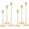 A set of three ornate vintage metal candle holders with slender stems and flared bases.