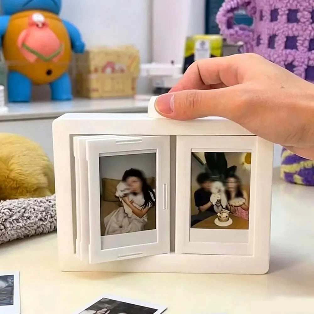 A hand is holding a white rotating flip photocard display frame with a picture inside.