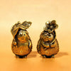 A small brass hedgehog statue with a flower on its head, sitting on an orange surface.