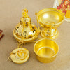 A gold-plated Orthodox censer with bells resting on a beige cloth.
