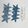A set of twelve wooden ocean ornaments featuring starfish, scallops, and other sea creatures in blue and white.