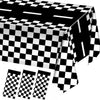 A black and white checkered tablecloth is draped on a table, with several folded checkered napkins visible.