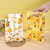 A hand is holding a yellow honeycomb gift bag filled with honey and bees for party favors.