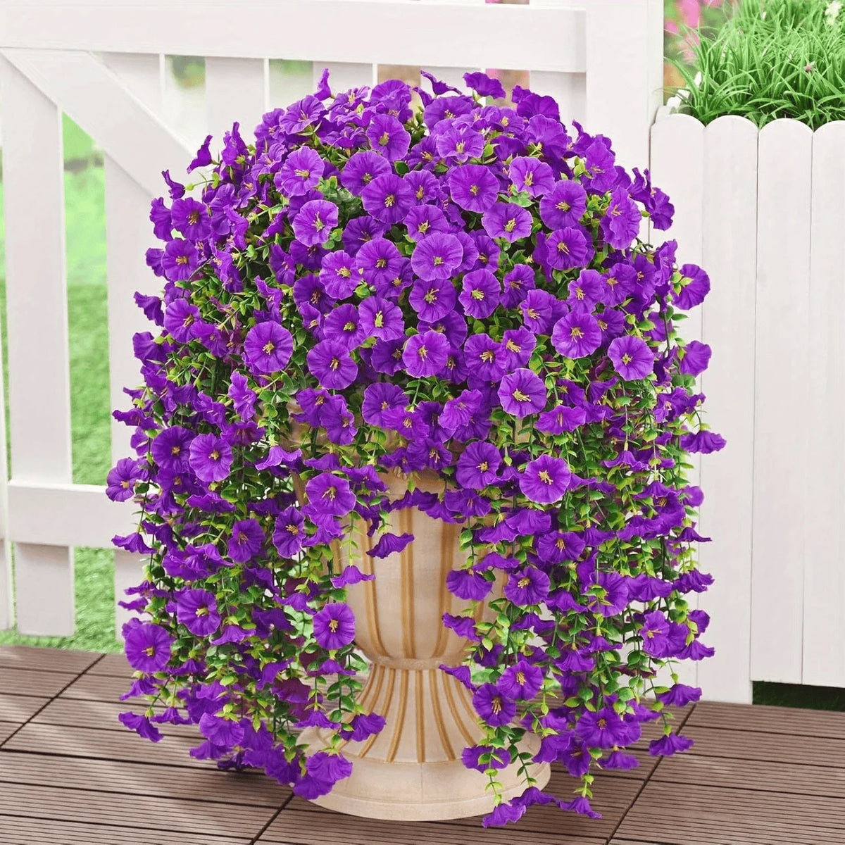 A dense display of purple artificial morning glory hanging vines in a white planter box.