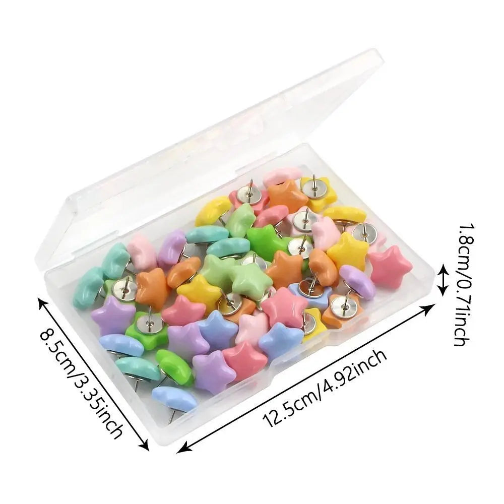 A clear plastic box filled with colorful decorative pentagram thumb tacks for crafting and display