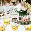 A collection of gold crown-shaped candy boxes displayed on a white table.
