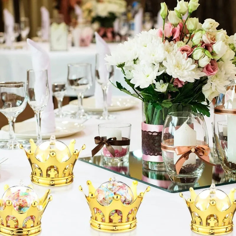 A collection of gold crown-shaped candy boxes displayed on a white table.