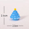 A small, light blue resin Christmas tree charm with a yellow star topper, shown against a white background.