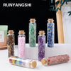 A collection of natural crystals in glass bottles and a rolled crystal healing bottle.
