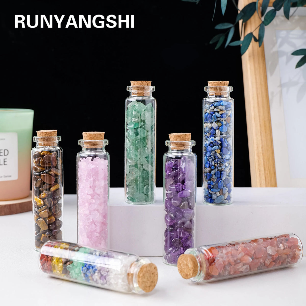 A collection of natural crystals in glass bottles and a rolled crystal healing bottle.