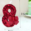 A red glitter number eight made of flowers with a matching red bow, shown against a white background.