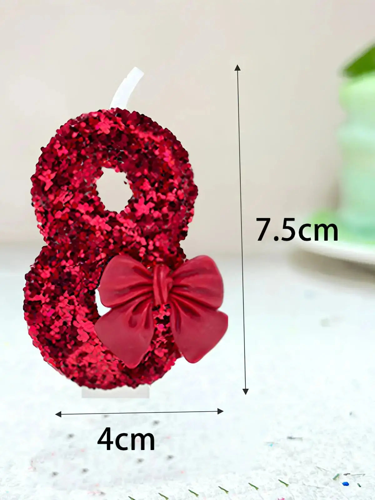 A red glitter number eight made of flowers with a matching red bow, shown against a white background.