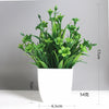 A potted artificial bonsai plant with green eucalyptus accents in a white rectangular pot.