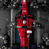 A close-up view of a red and black Formula 1 racing car model on a gray concrete surface.