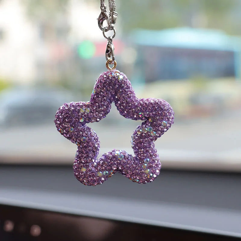 A purple rhinestone star charm hanging from a silver chain.