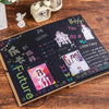 Ein dunkles Fotoalbum mit handschriftlichem Text und bunten Aufklebern auf einer Holzoberfläche.
