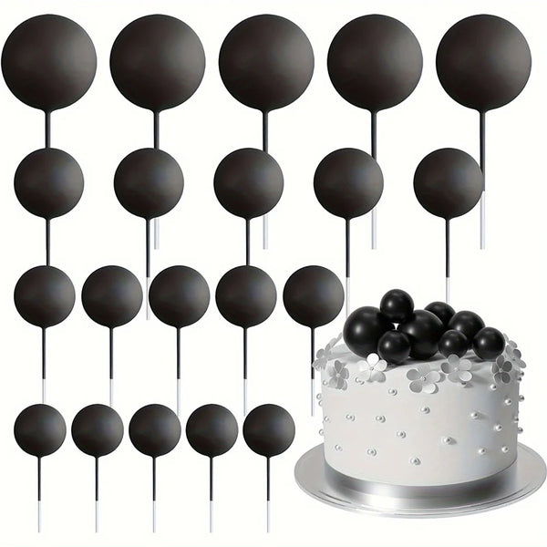 A set of twenty black mini foam ball cake toppers on sticks displayed above a white cake.