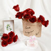 A bouquet of deep red glitter roses in a kraft paper bag with a small framed card.