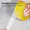A hand is applying clear tensile packing tape to a yellow object, demonstrating its strong tensile tension.