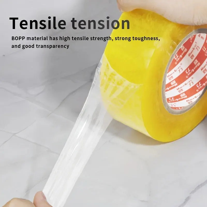 A hand is applying clear tensile packing tape to a yellow object, demonstrating its strong tensile tension.