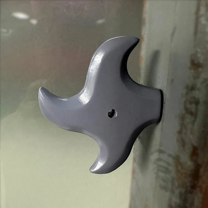 A gray 3D axe fridge magnet with a pointed head is shown against a light background.