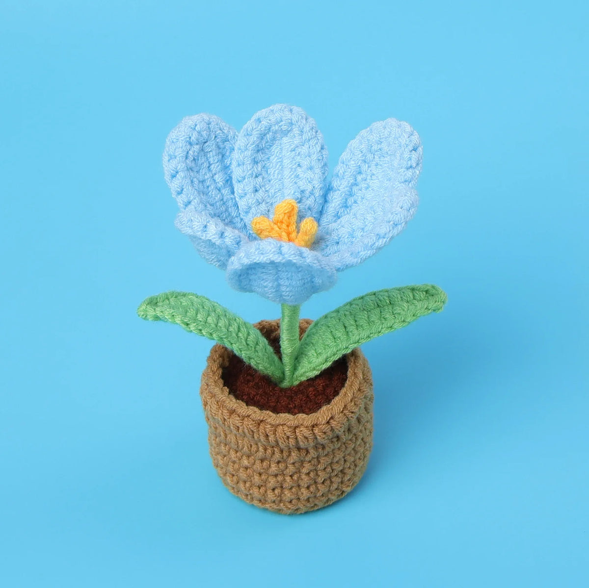 Handcrafted crochet blue tulip flower with an orange center growing in a brown pot.