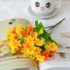 A bouquet of bright yellow and orange artificial daisy flowers displayed on a page of a book.