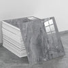 A large slab of gray marble peel-and-stick wall panel is displayed next to a stack of white panels.