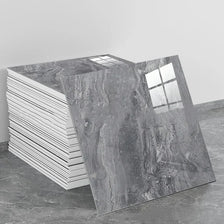 A large slab of gray marble peel-and-stick wall panel is displayed next to a stack of white panels.
