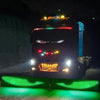 A black truck with bright LED lights and a green light effect on the ground.