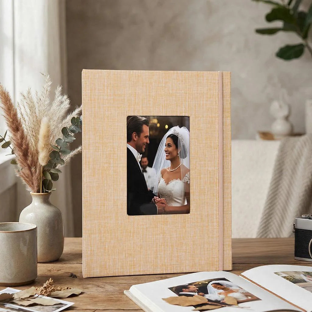 A light beige linen photo album with a framed picture of a couple on a wooden table.