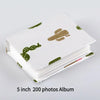 A stack of a 5 inch 200 photos album with green cactus designs on the cover.