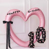 Pink heart-shaped balloon decoration with Happy and Birthday text